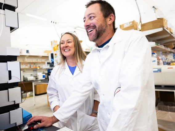 Drs. Ashley and Justin Snider laugh while looking at data in their labs.