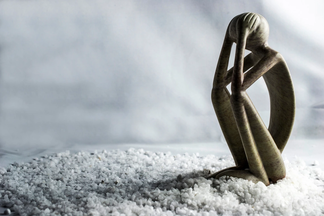 Stylized image of a human figure sitting in an attitude that communicates stress, anxiety, or sadness