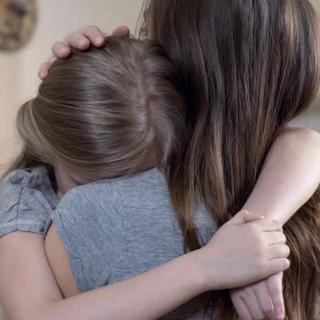 Mother embraces her frightened daughter